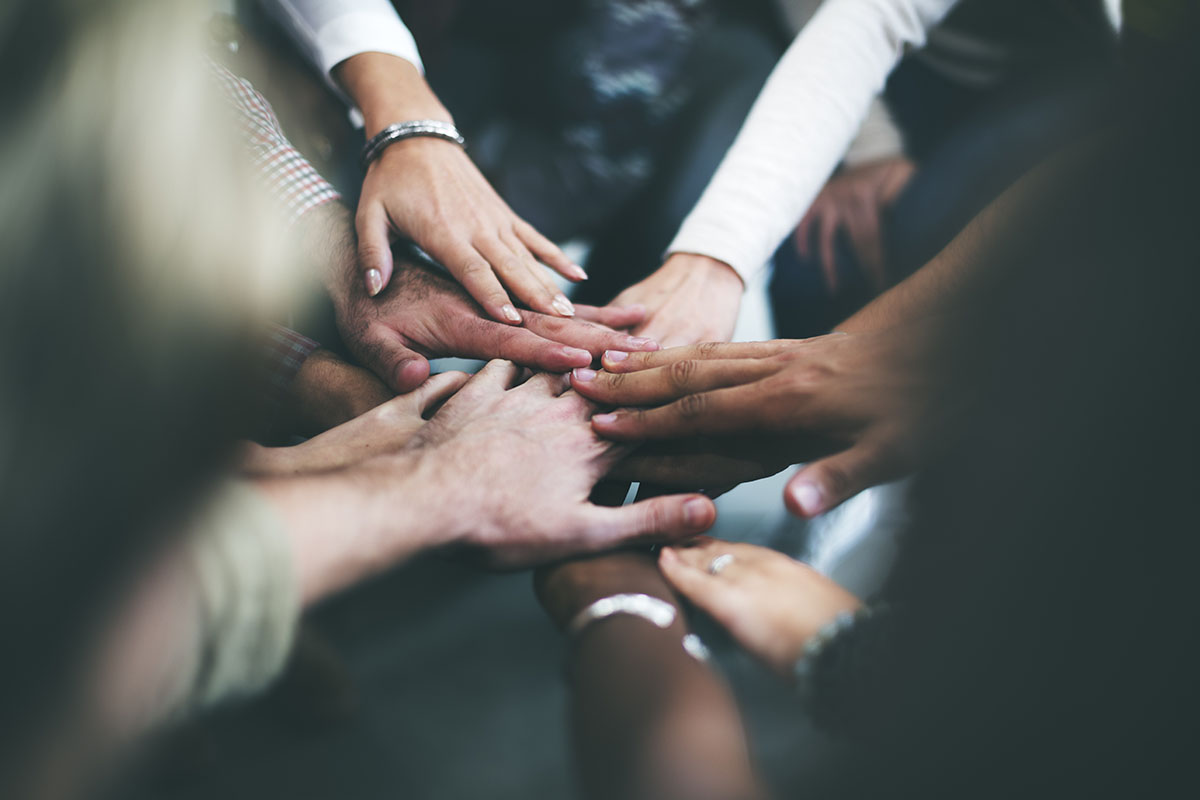 Teamwork and collaboration concept with hands joined together in a circle.